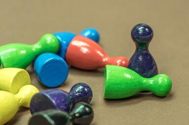 Vergrößerte Ansicht von kreuz und quer liegende bunte Spielfiguren 
