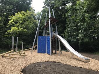 Vergrößerte Ansicht von Der Spielplatz am Stephanienufer hat 2021 im Sandbereich ein neues Sand-Klettergerät für jüngere Kinder und eine Kleinkinderschaukel bekommen. Für ältere Kinder gibt es dort jetzt eine hohe Zweifachschaukel und ein großes Klettergerät mit Rutsche. Ein weiteres Highlight ist die neue Seilbahn.