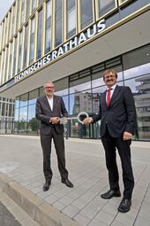 Vergrößerte Ansicht von Das Technische Rathaus im Glücksteinquartier wurde 2021 offiziell der Stadt und seiner Bestimmung übergeben. Das Bild zeigt den Geschäftsführer der GBG, Karl-Heinz Frings, bei der symbolischen Schlüsselübergabe an Oberbürgermeister Dr. Peter Kurz.