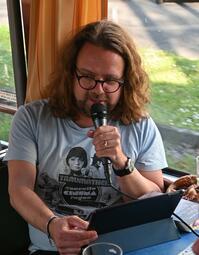 Vergrößerte Ansicht von Markus B. Altmeyer liest aus seinem Buch bei einer Stadtrundfahrt anlässlich des 130. Jubiläums der Stadtbibliothek Mannheim