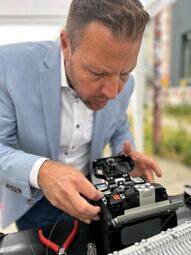 Vergrößerte Ansicht von Bürgermeister Dr. Proffen legt selbst Hand an und hilft beim Spleißen der Glasfaserkabel.