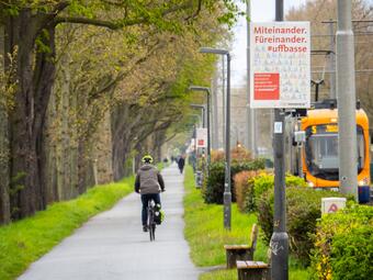 Vergrößerte Ansicht von Radweg am Neckardamm. Gesäumt von Plakaten, die auf ein rücksichtvolles Miteinander aufmerksam machen.