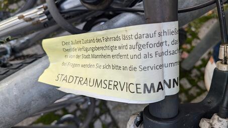 Vergrößerte Ansicht von Diese auffällige Banderole in Signalfarben fordert den/die Eigentümer*in auf, das Fahrrad unverzüglich zu entfernen