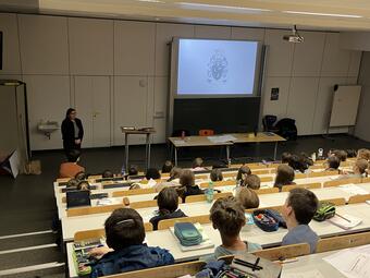Vergrößerte Ansicht von Gefüllter Hörsaal mit Dozentin und Präsentation