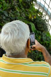 Vergrößerte Ansicht von Ein älterer Mann macht ein Foto mit dem Smartphone