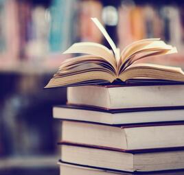 Vergrößerte Ansicht von Aufgeschlagenes Buch auf Bücherstapel