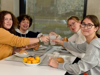 Schüler essen am Tisch in Mensa 