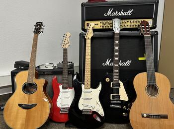 Elektrische und akustische Gitarren vor Verstärkern