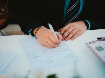 Person, die ein Dokument unterschreibt