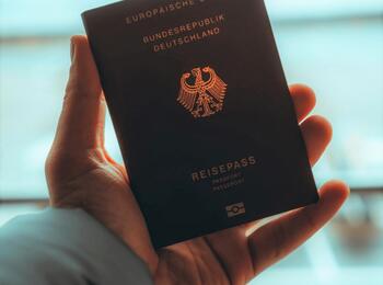 Eine Hand die einen deutschen Reisepass hält