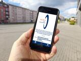 Eine Hand hält ein Handy. Auf dem Bildschirm ist die App Katretter zu sehen. Ein Text besagt, dass die gebietsübergreifende Alarmierung ab 01.10.2025 verfügbar ist