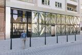 Eine Frau läuft auf den Eingang eines Museums mit auffälliger Glassfassade zu